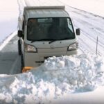 Off-road Japanese kei truck plowing snow