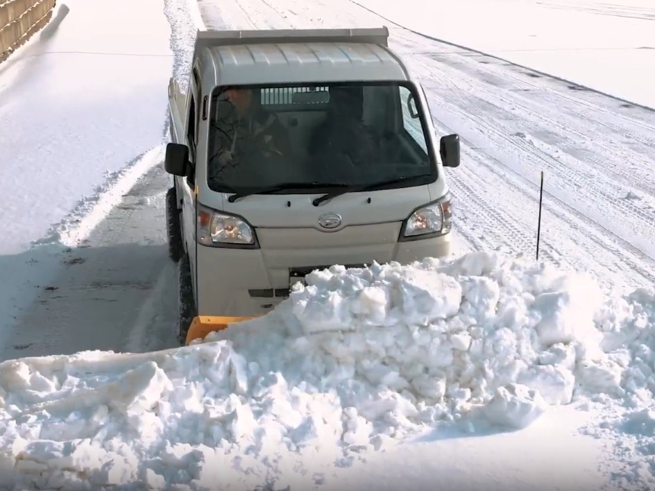 Off-road Japanese kei truck plowing snow
